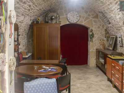 ...ci apre la porta di un luogo con mura in pietra e volte a botte, diviso in due ambienti tramite una tenda rossa di velluto